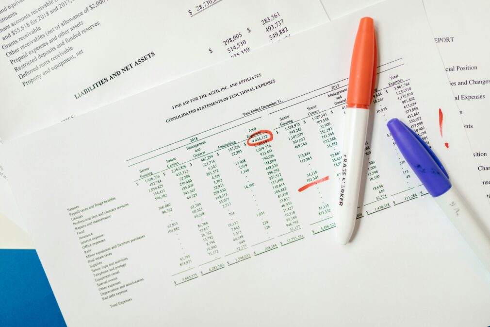 Close-up of financial documents with highlighted figures and marker pens.