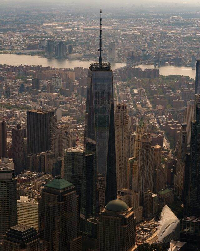 Stunning aerial view of One World Trade Center towering over New York City skyline with Hudson River
