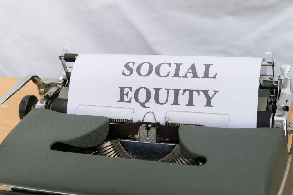 Close-up of a vintage typewriter displaying the message 'Social Equity' on paper.