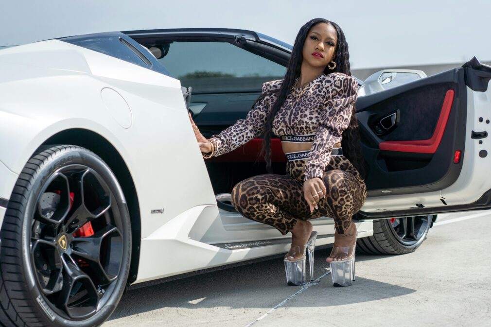 A fashionable woman in animal print by a white supercar in Columbia, MD.