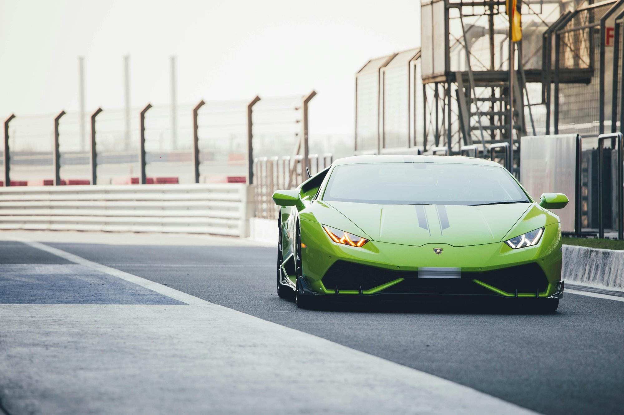 Green Lamborghini Huracan racing on a Noida track in India, showcasing speed and luxury.