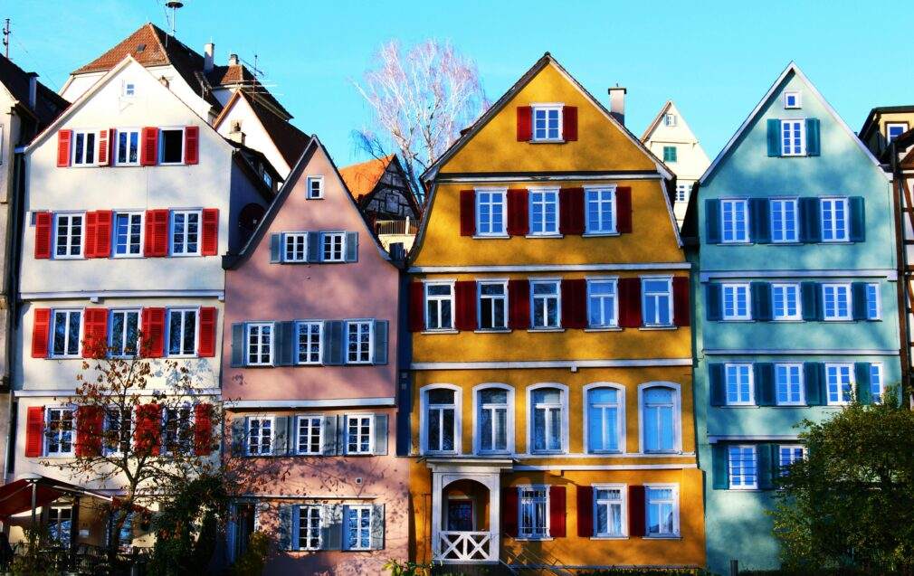 Vibrant facades of traditional houses in Tübingen's historic center, under a clear daytime sky.