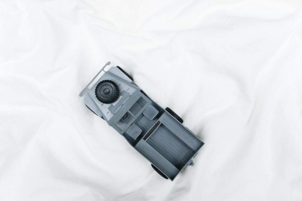 Overhead view of a grey plastic model military vehicle on a white background, ideal for hobby enthusiasts.