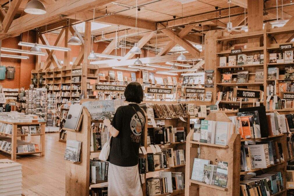A woman browses books in a warm, cozy bookstore in Seattle.